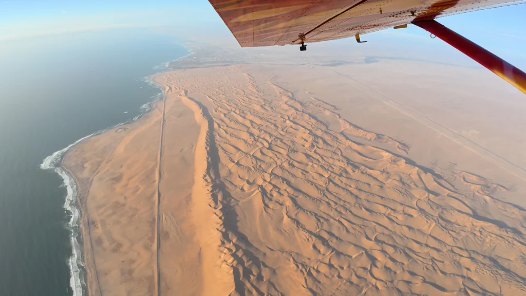Aerial view of rippled Swakopmund dunes meeting the Atlantic coastline