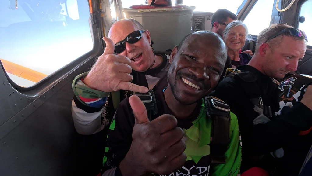 tandem skydiving passengers inside aircraft preparing for jump in Namibia