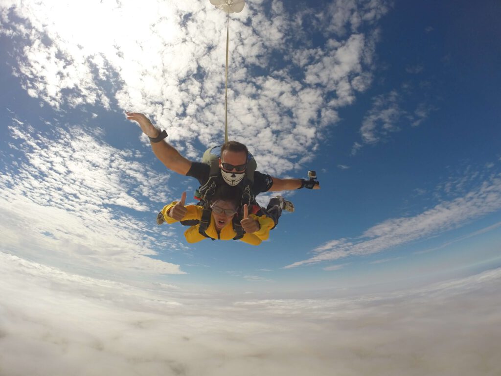 Instructor and passenger in yellow jacket during tandem skydive Swakopmund freefall