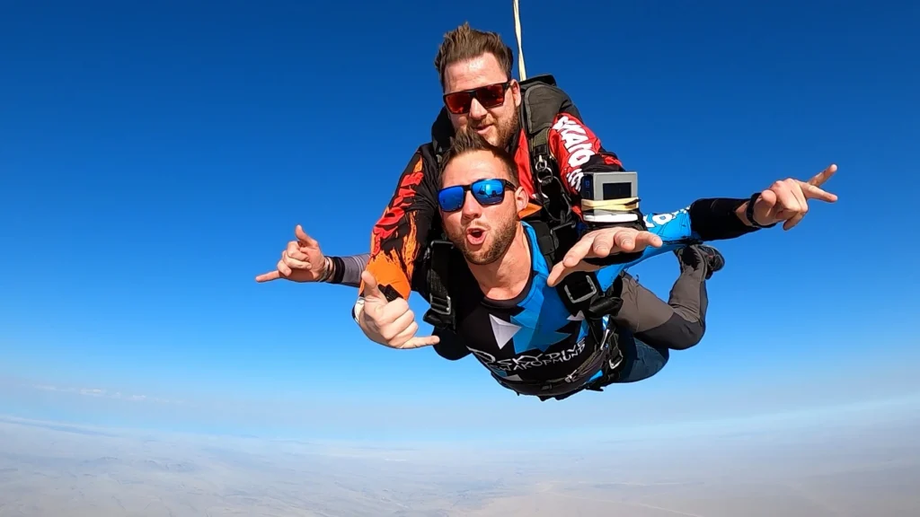 Tandem skydive close-up with instructor and guest smiling in freefall