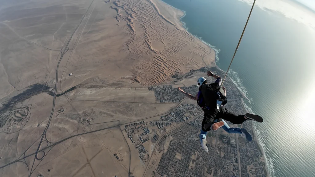 Tandem pair freefall above the rippled Swakopmund dunes near the coast