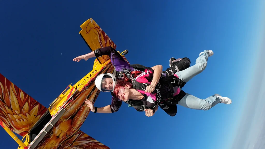Tandem duo leap from the flame-painted aircraft on a skydiving Namibia jump