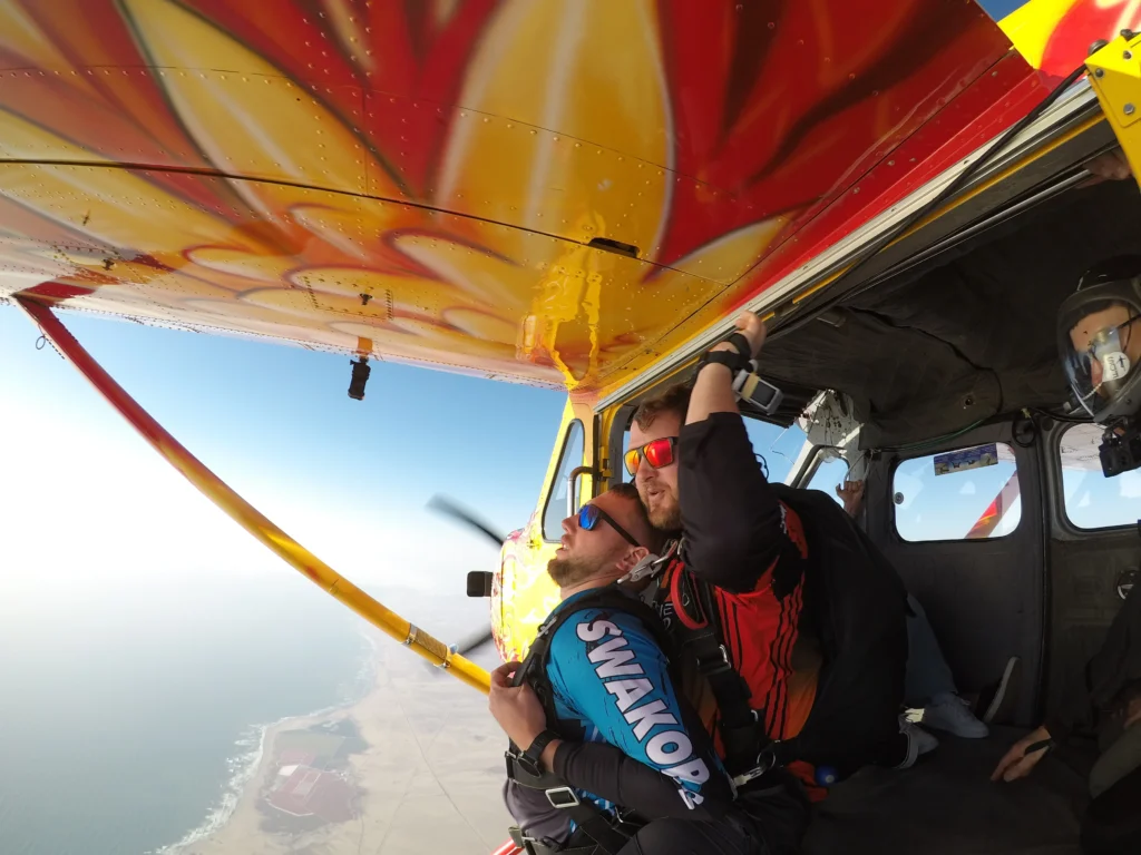 Skydivers prepare to exit the aircraft during a skydiving Namibia flight