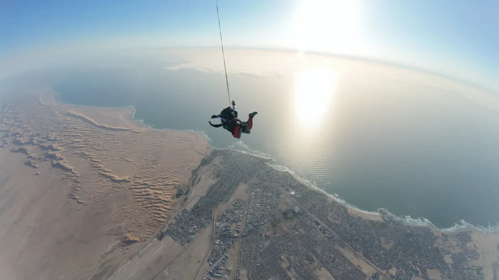 Tandem pair in freefall high above Swakopmund town and the sunlit Atlantic coast