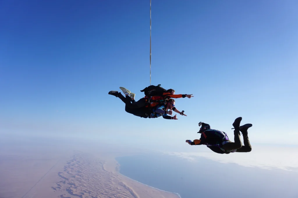 Tandem pair and cameraman freefall together above the Atlantic coast skydive zone