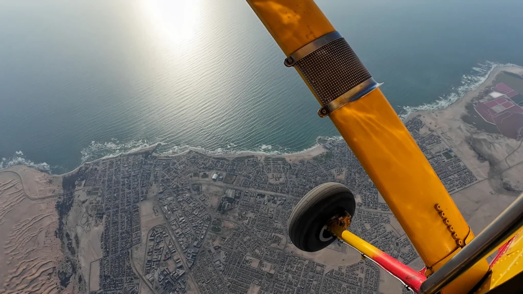 View past the plane's wheel strut over the ocean and coastline, Atlantic coast skydive