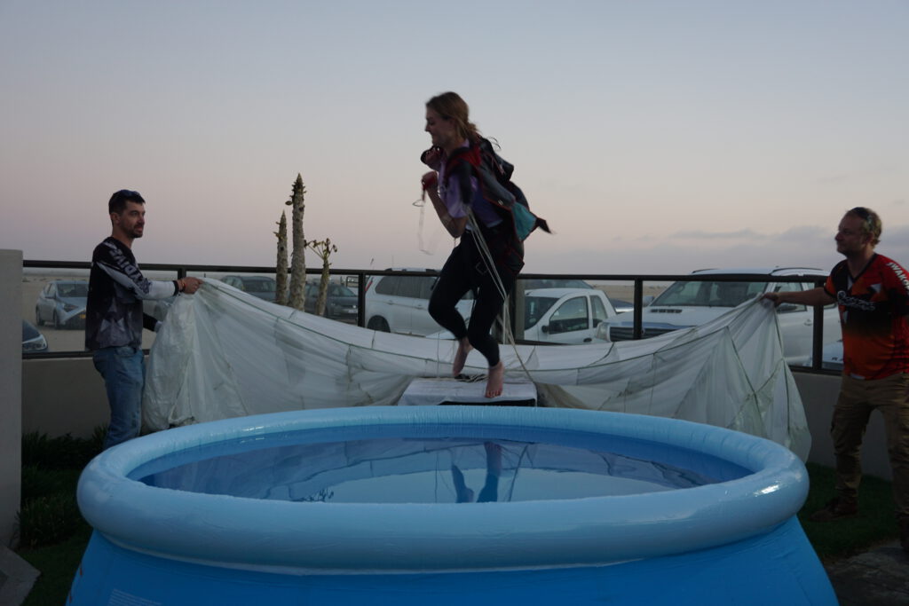 Woman leaps barefoot into a celebration pool overlooking the skydive Namibia coast