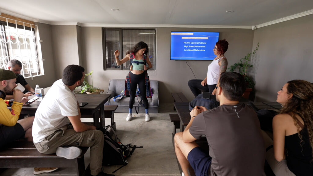 AFF student in a harness practices emergency procedures during a skydiving theory class in Swakopmund