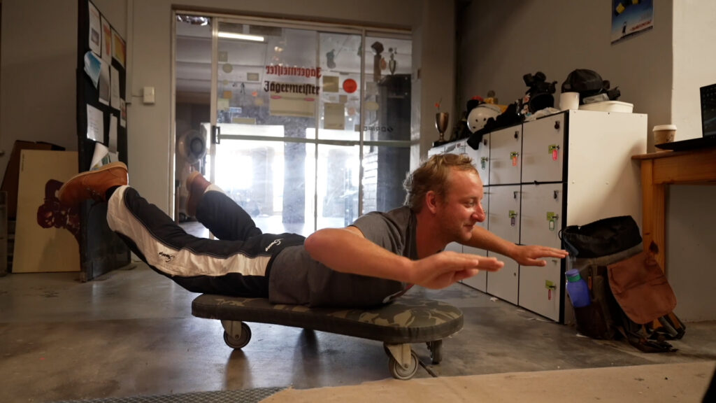 Man practices freefall body position lying on a rolling platform