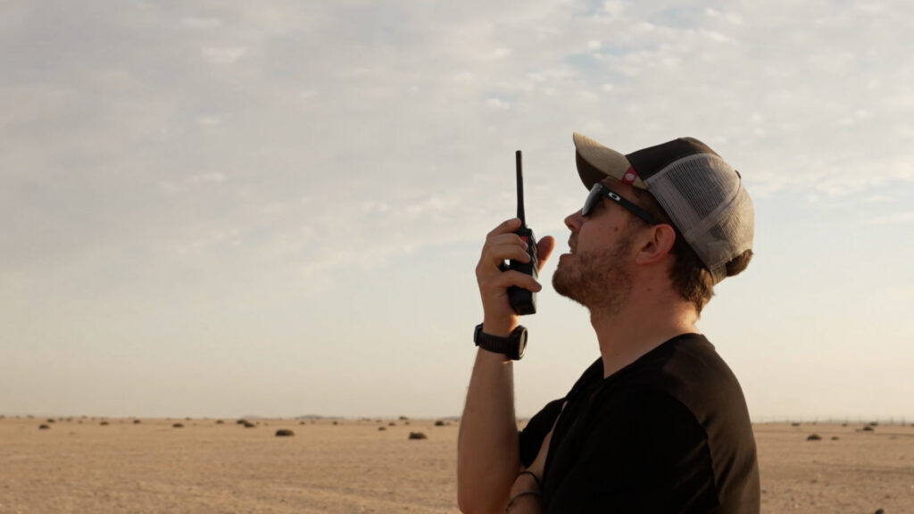 Trained skydiver using radio communication to guide a student during an AFF skydive in Swakopmund, Namibia
