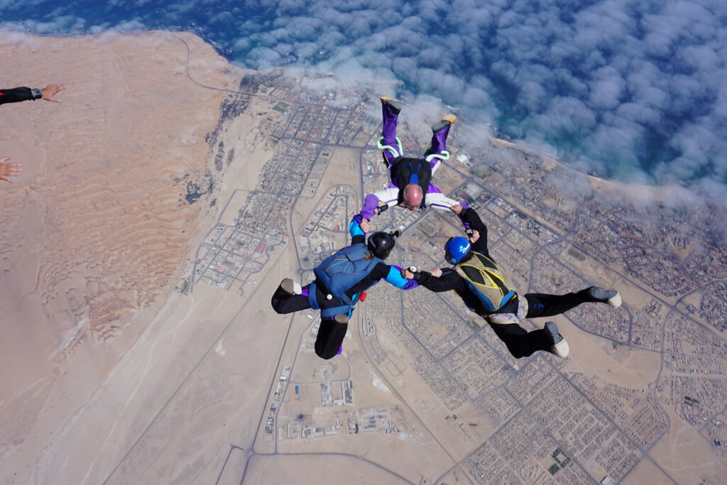 Three-way skydiving formation above Swakopmund during a skydive Namibia coast jump