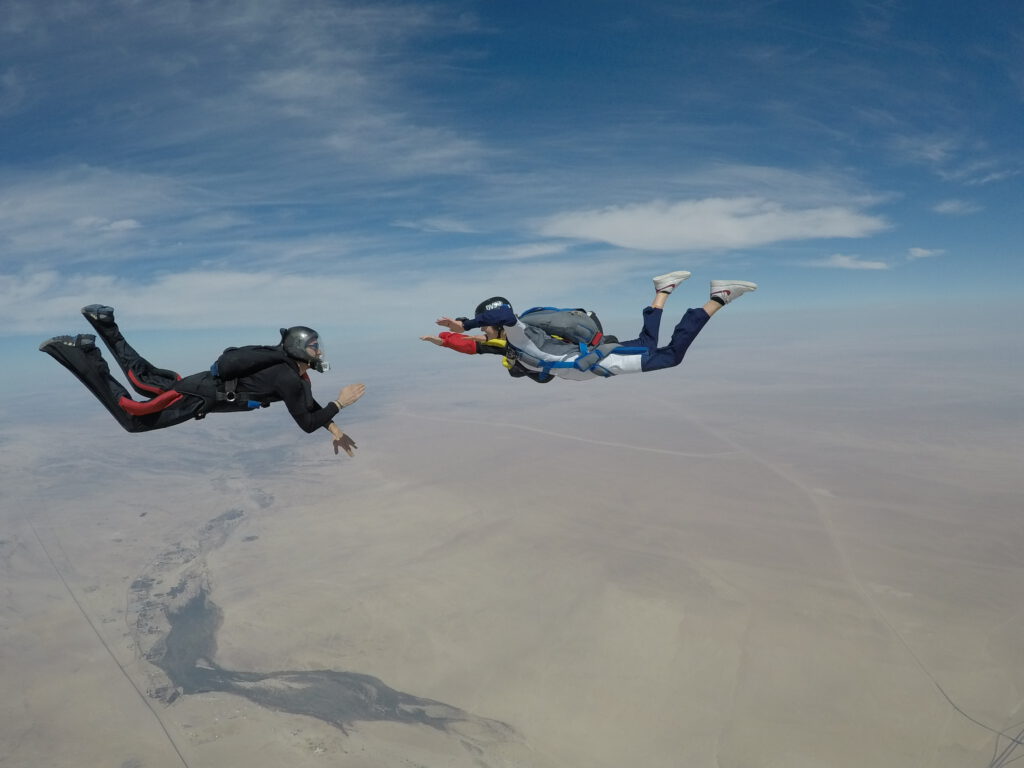 Instructor and student in freefall during a skydive Namibia coast descent near the dunes