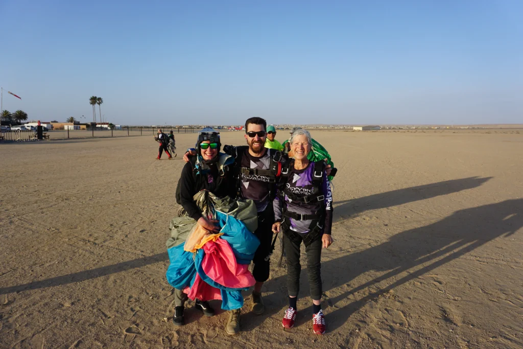 Tandem skydive Swakopmund instructor and two happy passengers pose after landing