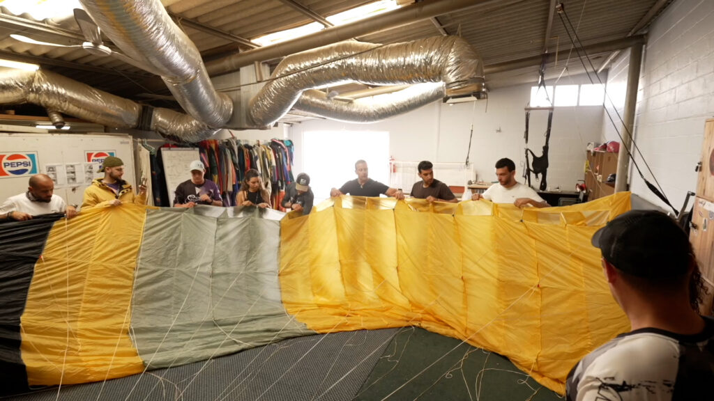 AFF students hold up a large canopy to inspect it during packing training in the Swakopmund hangar