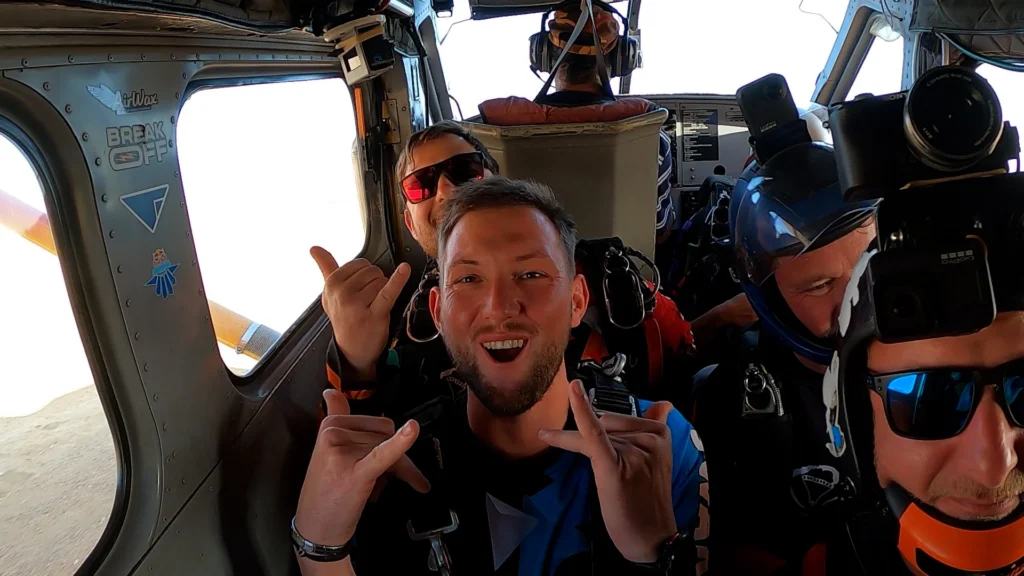 Excited jumpers pose inside the cabin before a tandem skydive Swakopmund flight