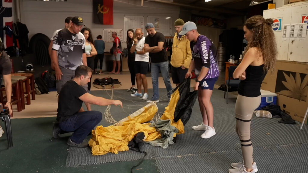 Instructor demonstrates canopy packing to AFF students in the Skydive Swakopmund hangar