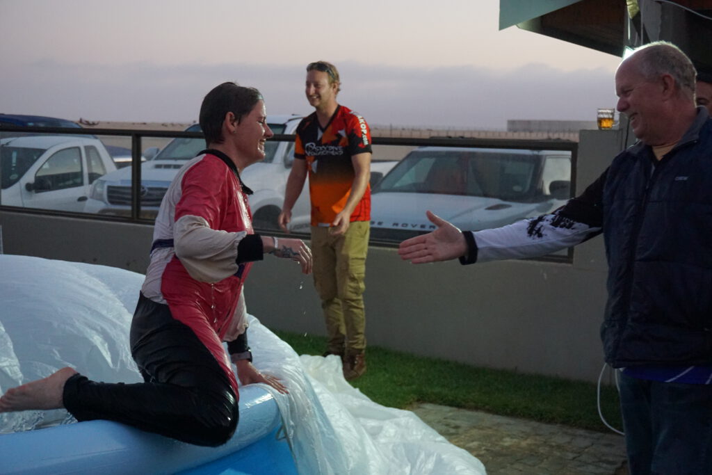 Skydiving team member slides out of pool during an evening celebration
