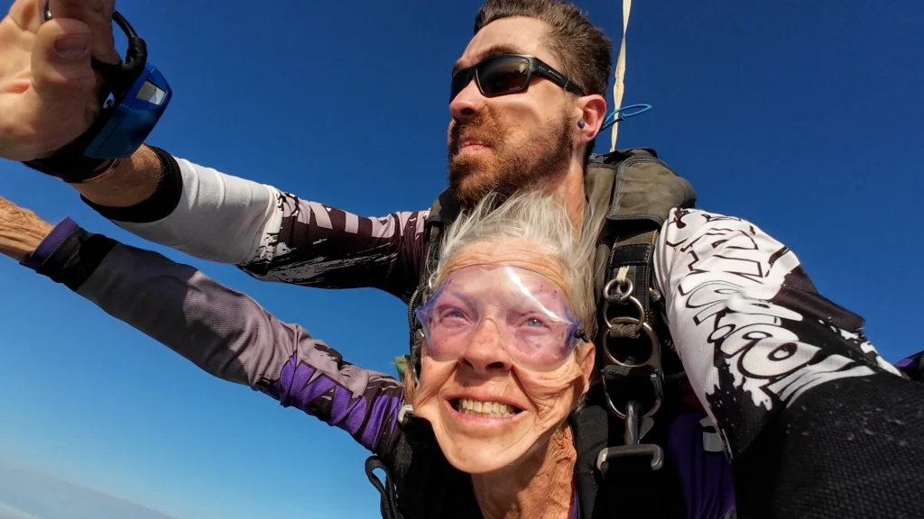 Senior tandem skydiver enjoying freefall captured on handcam over Swakopmund Namibia