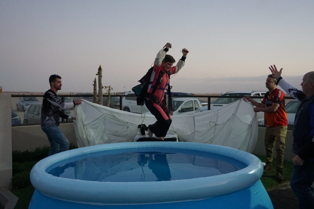 Jumper in a red flight suit leaps triumphantly into a celebration pool