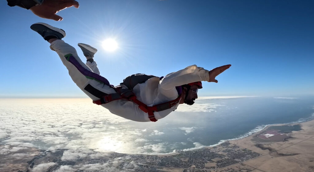 Skydiver student falls freely above the town during an Atlantic coast skydive